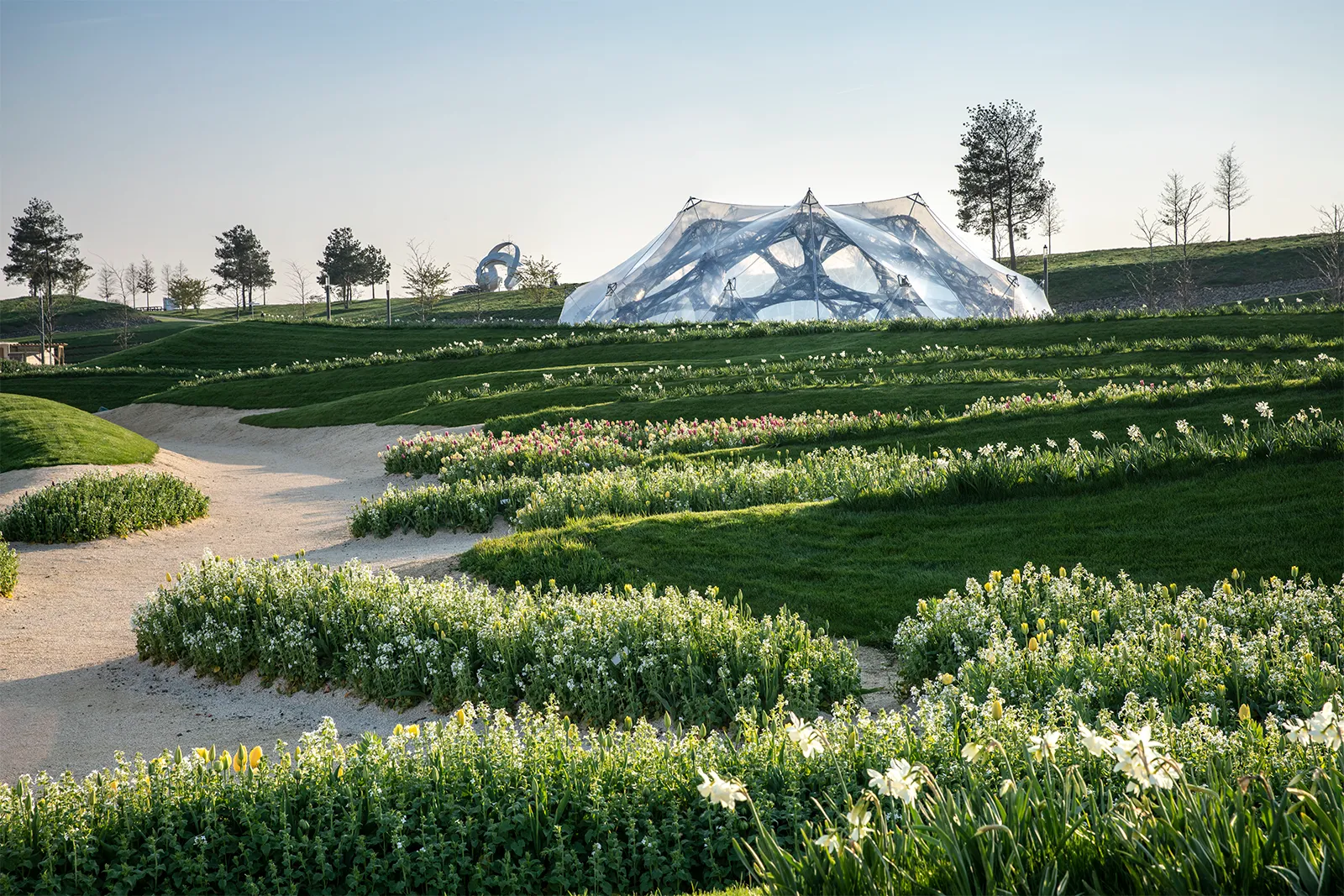 BUGA Fibre Pavilion 2019, casca translúcida de fibras enroladas em campo de narcisos