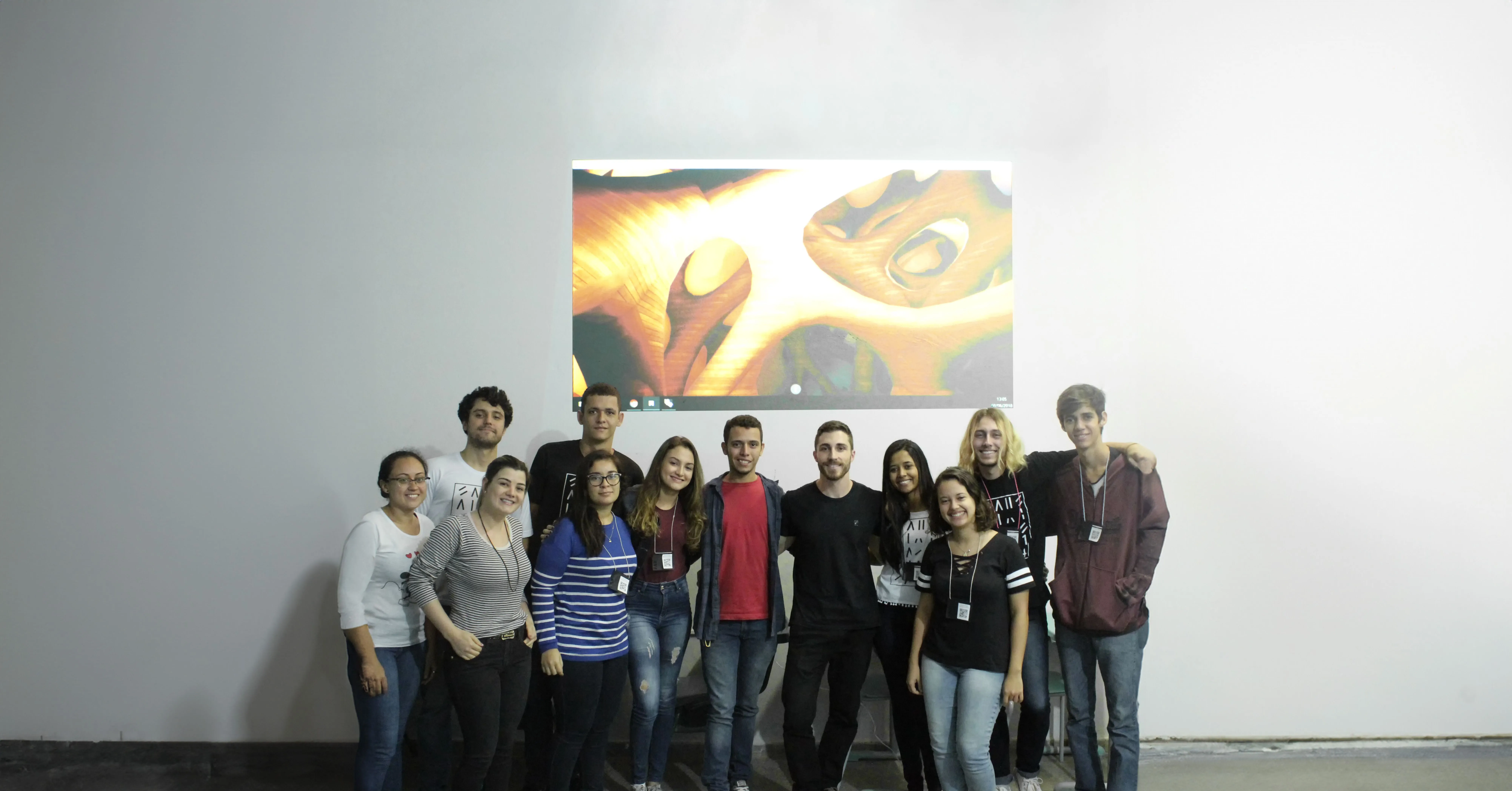 Foto de grupo com todos os alunos e o resultado do workshop ao fundo.