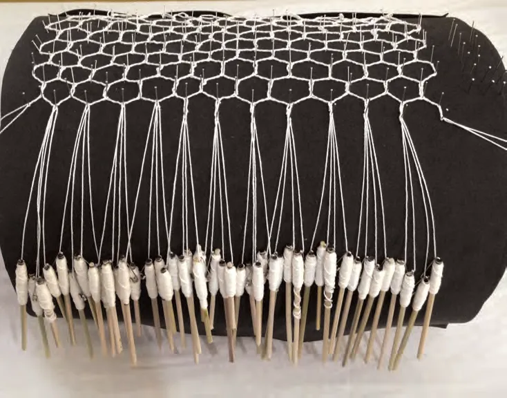 Bobbins in use during lace production