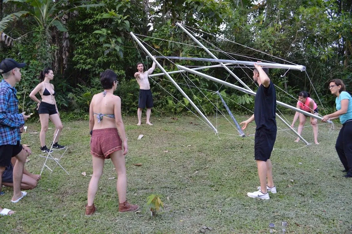 A equipe tensionando cabos para estabilizar a estrutura em crescimento.