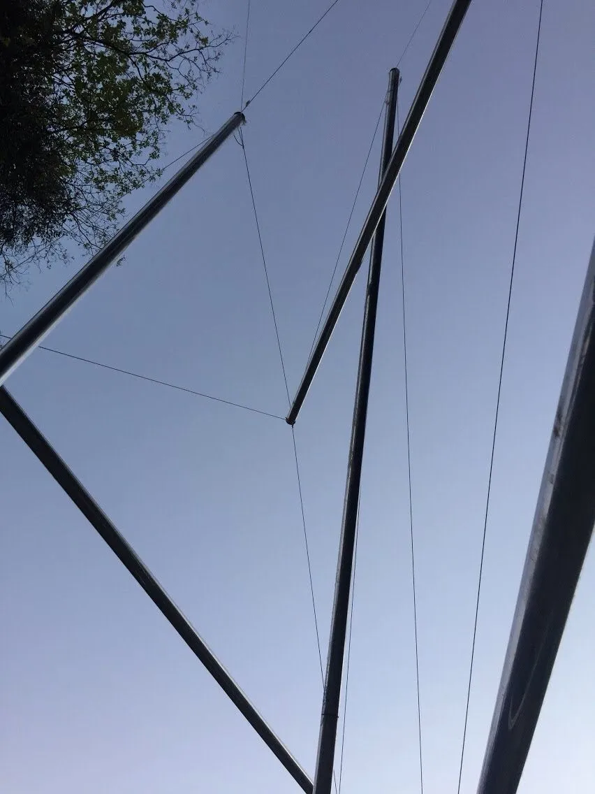 Vista de detalhe olhando para cima através das barras e cabos da tensegridade contra o céu.
